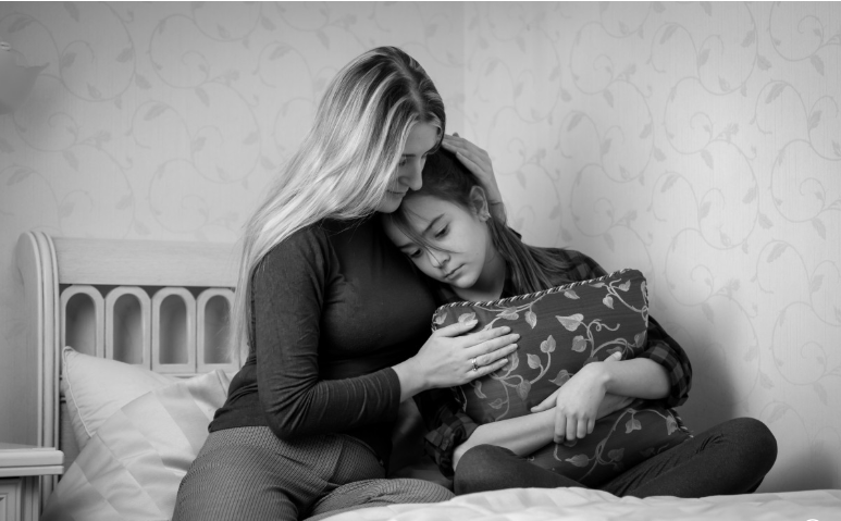 Mother comforting her daughter with care and warmth about Mutual Climax awareness.