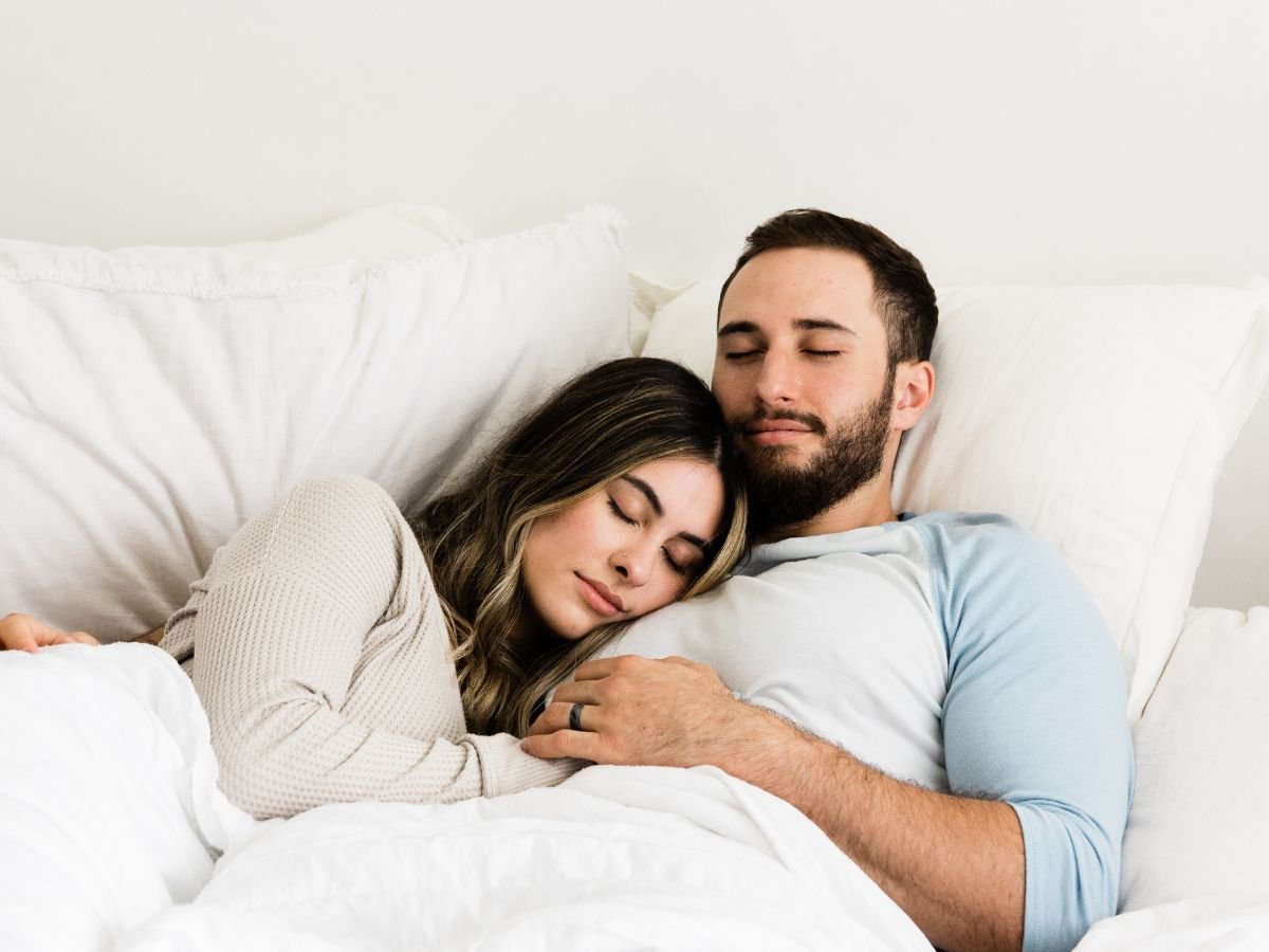 Couple resting together in bed, showing comfort and closeness that support Mutual Climax